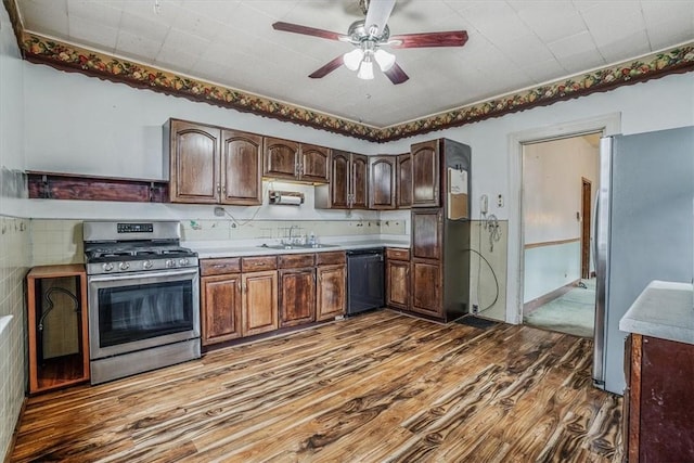 kitchen featuring sink, dark hardwood / wood-style floors, ceiling fan, appliances with stainless steel finishes, and dark brown cabinetry