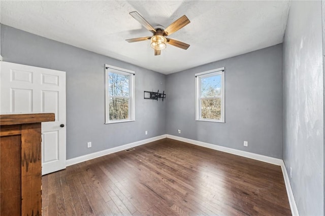 spare room with ceiling fan and dark hardwood / wood-style flooring