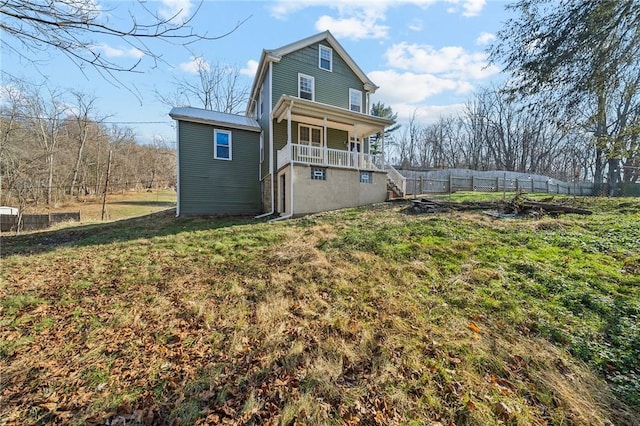 rear view of house featuring a porch and a yard