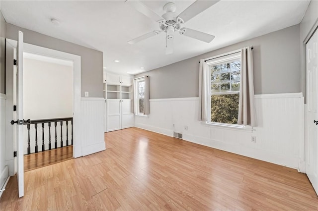 spare room with ceiling fan and light wood-type flooring