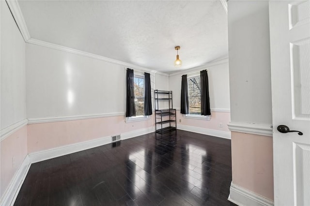 empty room featuring ornamental molding and dark wood-type flooring