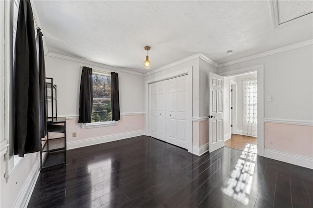 unfurnished room with a textured ceiling, crown molding, and dark wood-type flooring