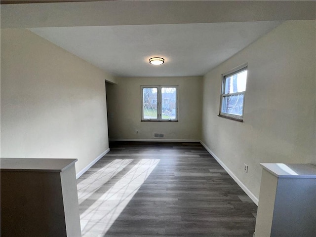 spare room with dark wood-type flooring