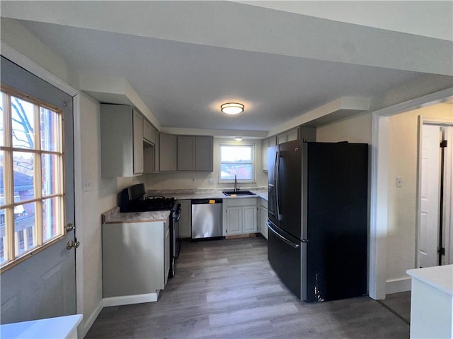 kitchen featuring gray cabinetry, sink, dark wood-type flooring, and appliances with stainless steel finishes