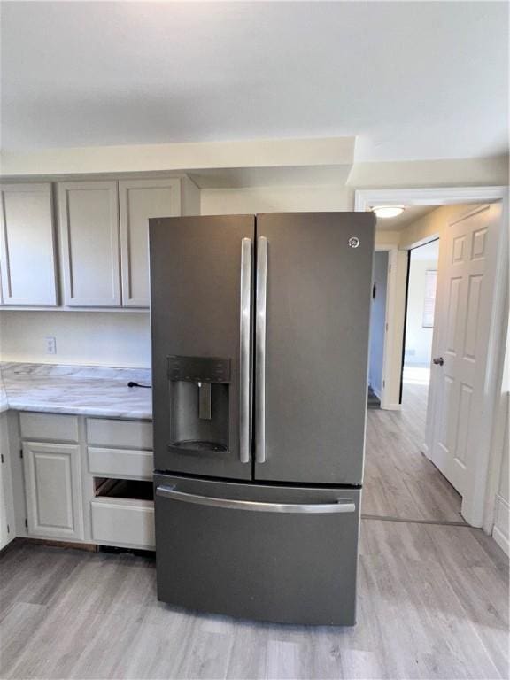 kitchen featuring gray cabinets, stainless steel refrigerator with ice dispenser, and light wood-type flooring