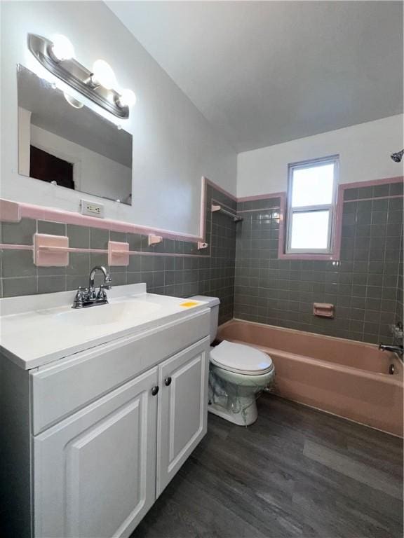 full bathroom with backsplash, hardwood / wood-style flooring, tile walls, toilet, and tiled shower / bath