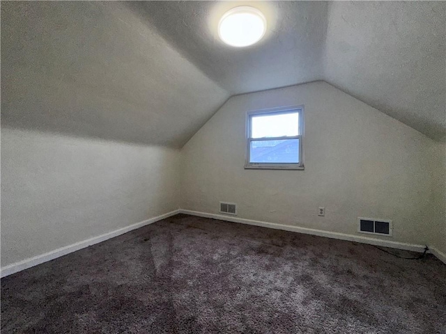 bonus room with carpet, a textured ceiling, and vaulted ceiling