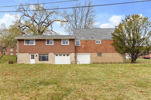 rear view of house featuring a yard and a garage