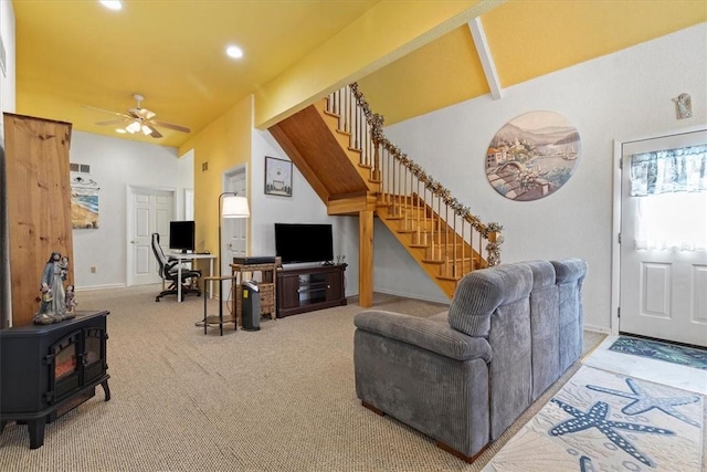 living room with vaulted ceiling, carpet floors, ceiling fan, and a wood stove