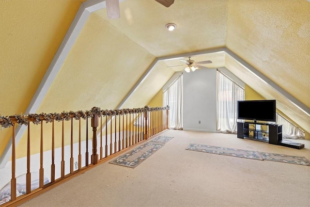 bonus room with carpet flooring, a textured ceiling, ceiling fan, and vaulted ceiling