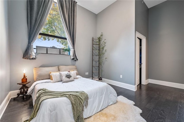 bedroom featuring dark hardwood / wood-style floors and lofted ceiling