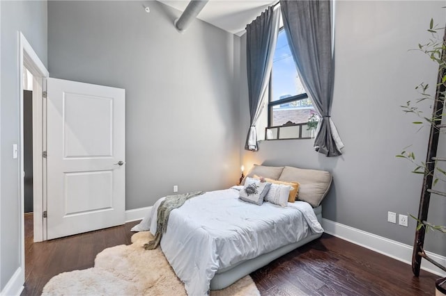 bedroom with dark wood-type flooring