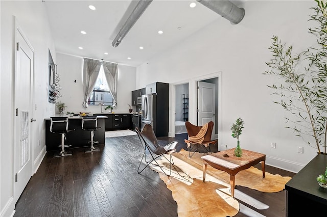 living room featuring a towering ceiling and dark hardwood / wood-style flooring