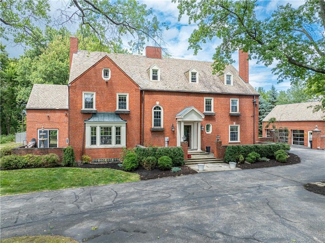 705 E Beau St E, Washington Boro, PA 15301 - view of front of home with a chimney, brick siding, an outdoor structure, and a front lawn