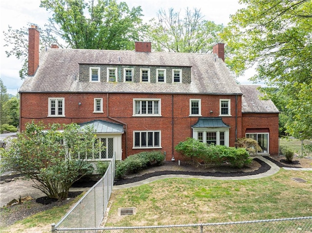 rear view of house featuring a yard