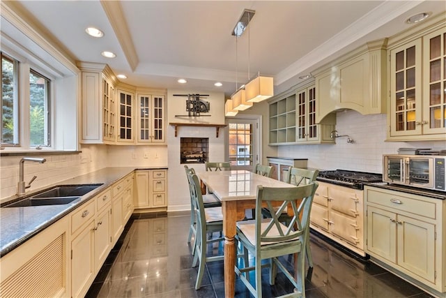 kitchen featuring cream cabinetry, decorative light fixtures, and sink