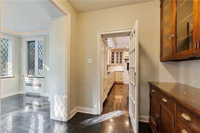 interior space featuring dark tile patterned flooring, ornamental molding, and radiator