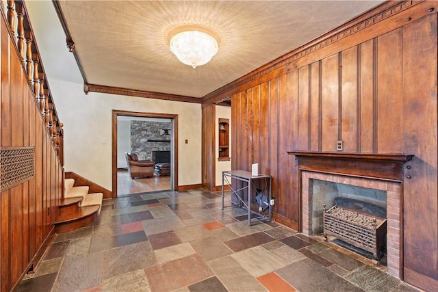 interior space featuring wood walls and ornamental molding