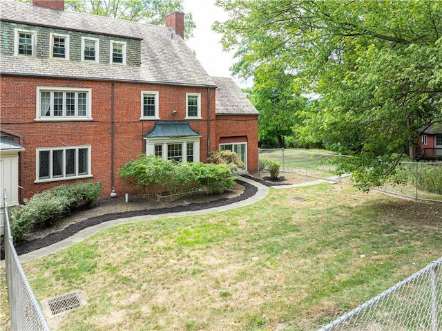 back of property featuring a lawn