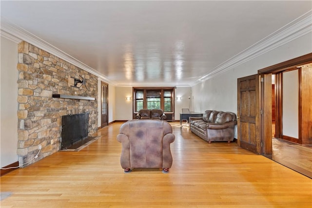 living room featuring light hardwood / wood-style floors, crown molding, and a fireplace