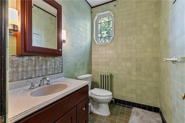 bathroom with vanity, toilet, tile walls, and radiator