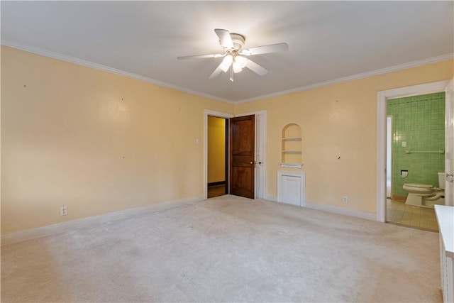 unfurnished bedroom featuring ensuite bath, ceiling fan, crown molding, and light carpet