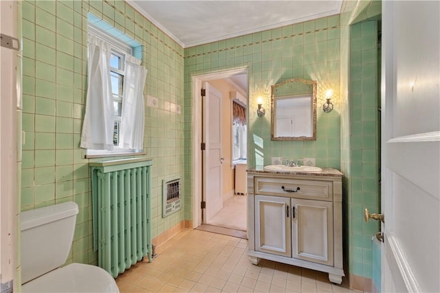 bathroom with vanity, radiator, tile patterned flooring, tile walls, and heating unit