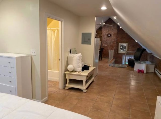 bedroom featuring connected bathroom, electric panel, tile patterned flooring, and lofted ceiling