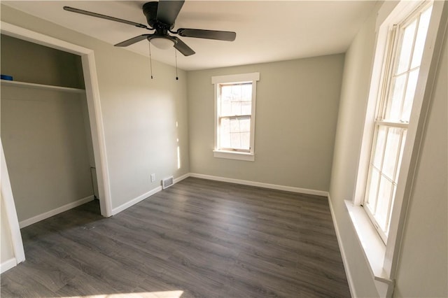 unfurnished bedroom featuring ceiling fan, dark hardwood / wood-style flooring, and a closet