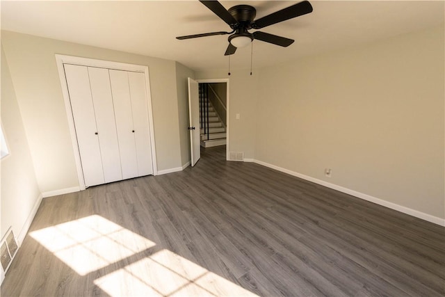 unfurnished bedroom featuring ceiling fan, a closet, and dark hardwood / wood-style floors