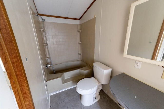 bathroom featuring crown molding, tile patterned flooring, toilet, tiled shower / bath, and lofted ceiling