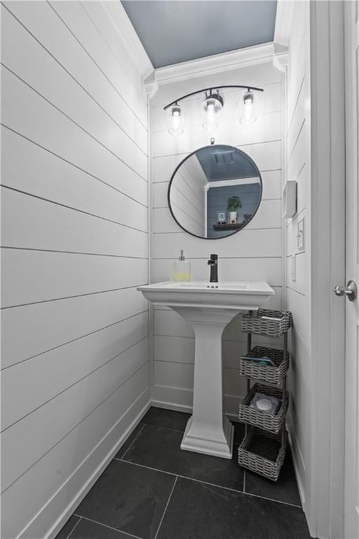 bathroom with tile patterned flooring and wood walls