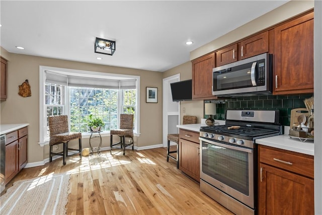 kitchen with tasteful backsplash, light hardwood / wood-style flooring, and stainless steel appliances