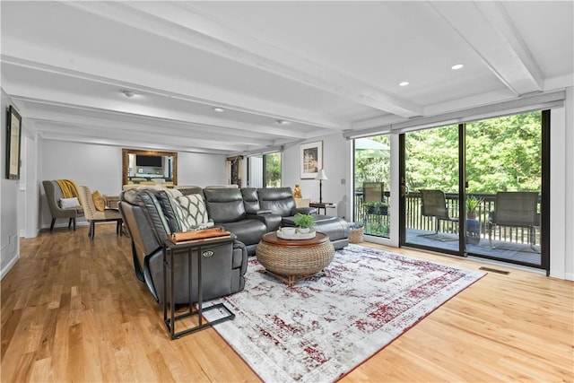 living room featuring beam ceiling and light hardwood / wood-style floors