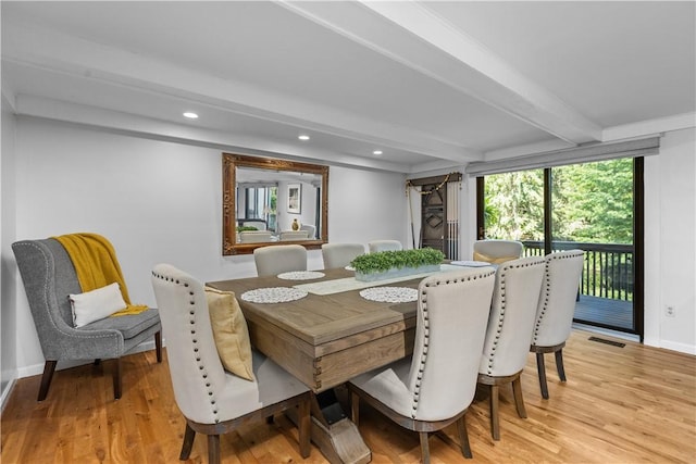 dining room featuring beamed ceiling and light wood-type flooring