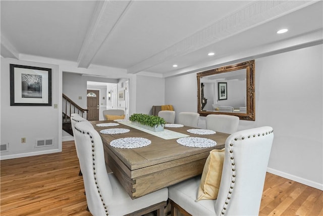 dining area featuring hardwood / wood-style flooring and beamed ceiling