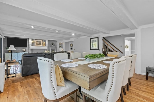 dining space with beam ceiling and light hardwood / wood-style flooring