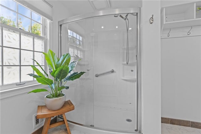 bathroom featuring a wealth of natural light and a shower with shower door