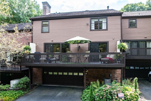 back of house with a garage and a wooden deck