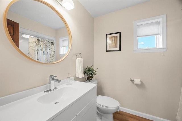 bathroom with vanity, toilet, and wood-type flooring