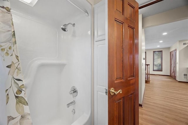 bathroom featuring hardwood / wood-style flooring and shower / bath combo