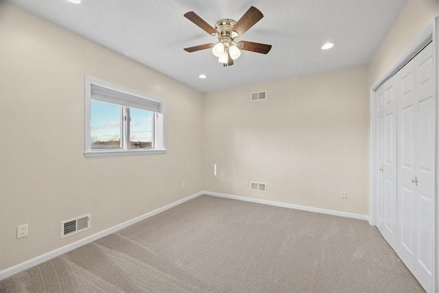 unfurnished bedroom with light carpet, a closet, and ceiling fan