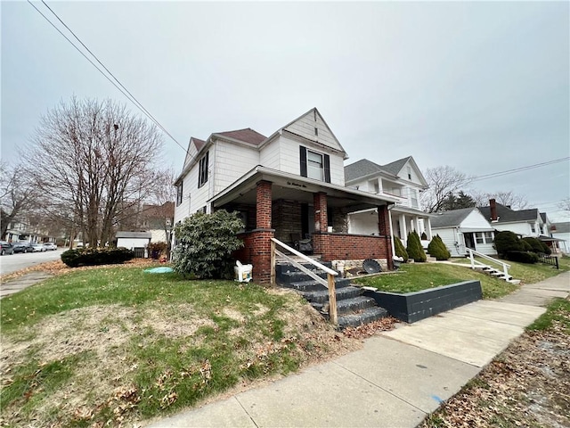 view of front of property featuring covered porch and a front lawn