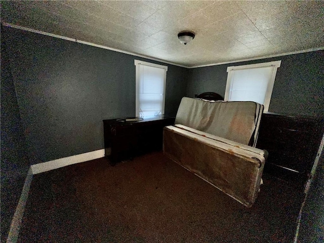 unfurnished bedroom with dark colored carpet and ornamental molding