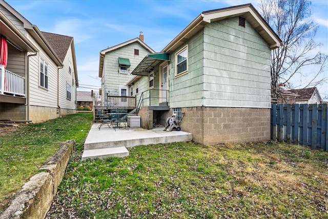 back of property with a lawn and a patio