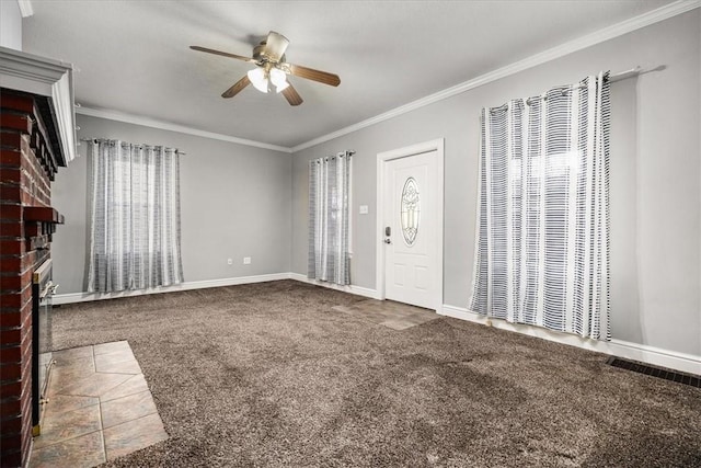 carpeted entrance foyer featuring ceiling fan, ornamental molding, and a brick fireplace