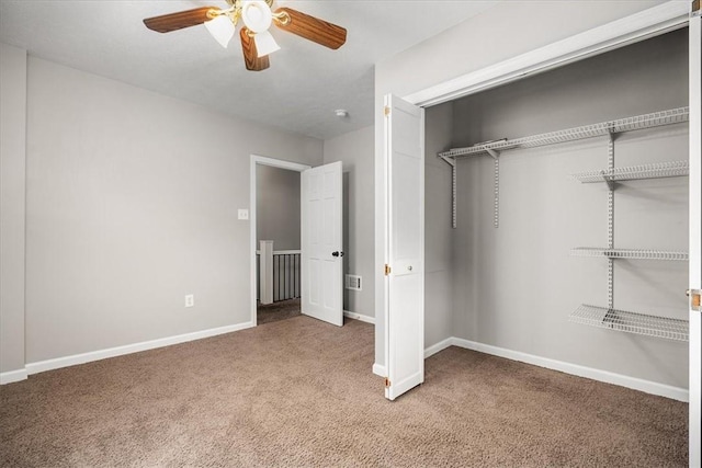 unfurnished bedroom with ceiling fan, a closet, and carpet floors