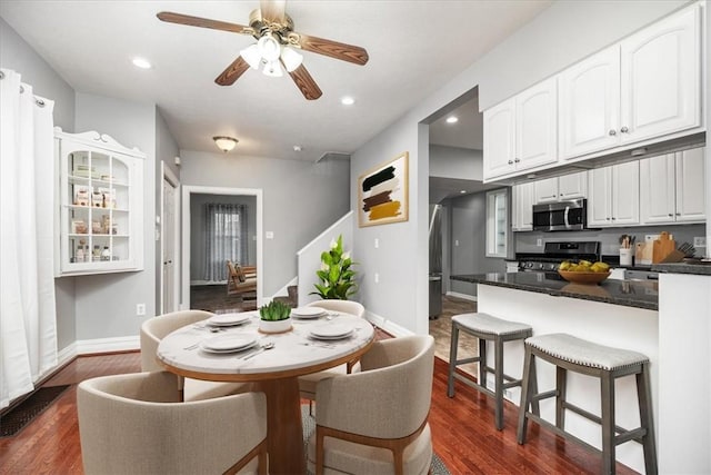 dining room with ceiling fan and dark wood-type flooring