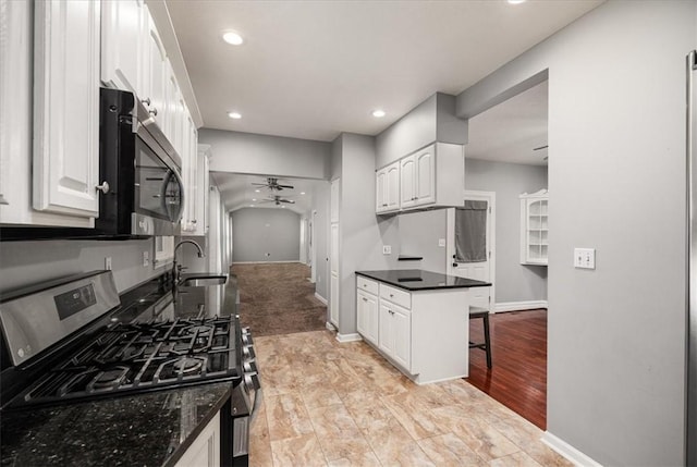 kitchen with stainless steel appliances, white cabinetry, ceiling fan, and sink