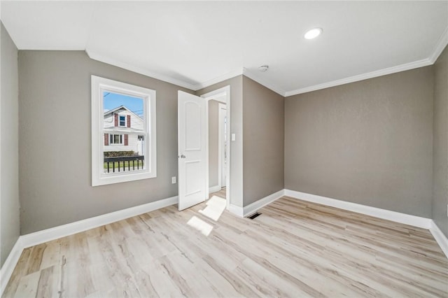 spare room featuring light hardwood / wood-style flooring and ornamental molding